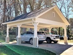 two cars are parked in the driveway under a covered carport on a sunny day