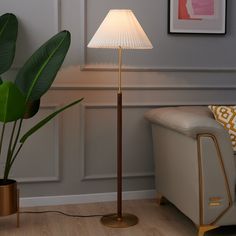 a living room scene with focus on the floor lamp and couch in the foreground