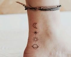 a woman's foot with two small tattoos on it, and the sun and moon