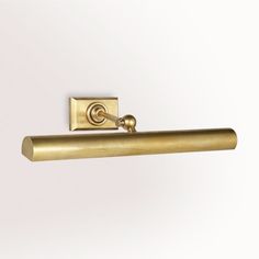 a brass toilet roll holder on a white wall