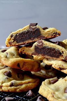 chocolate chip cookies stacked on top of each other with one broken cookie in the middle