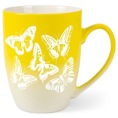 a yellow and white coffee cup with butterflies on it