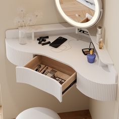 a white vanity with drawers underneath a round mirror