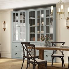 a dining room table and chairs in front of a china cabinet