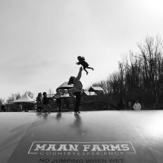 a man riding a skateboard up the side of a ramp with a child on his back