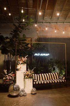 a room filled with lots of plants and flowers on top of a wooden floor next to a couch