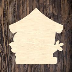 a cutout of a house on top of a wooden surface with the word home above it