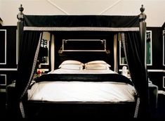 a black and white bedroom with four poster bed