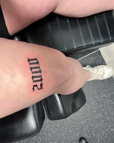 a woman's leg with the word tattoo on her left side and foot in black ink