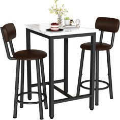 a table with two stools and a vase on the top is next to it