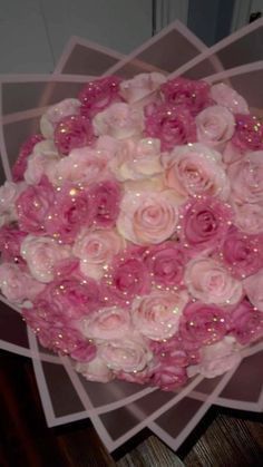 a bouquet of pink and white roses on top of each other in front of a door