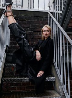 a woman sitting on some stairs with her feet up