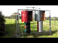 several barrels are stacked on top of each other in the grass near some trees and bushes