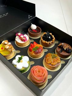 an open black box filled with different types of cakes and pastries on top of each other