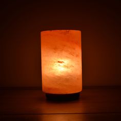 a lit candle sitting on top of a wooden table