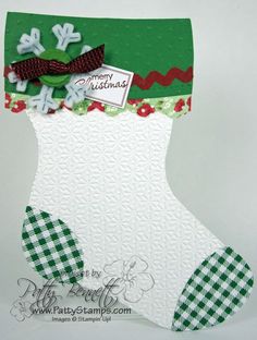 a green and white christmas stocking with a tag on it