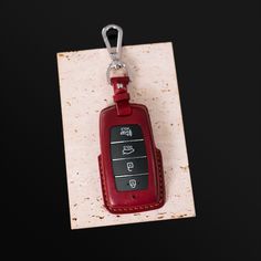 a red leather keychain hanging from a metal hook