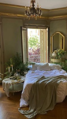 a large bed sitting in the middle of a bedroom next to two tables and chairs