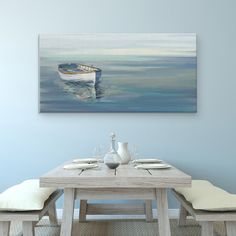 a dining room table with two chairs and a painting on the wall