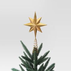 a gold star hanging from the top of a christmas tree with spirals on it