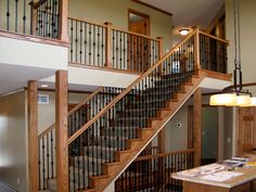 an open staircase leading to the second floor in a new construction home with wood railings and wrought iron balconies