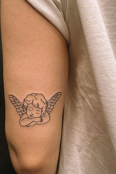 a woman's arm with an angel tattoo on the left side of her body