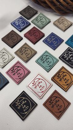 a bunch of different colored stickers sitting on top of a white table next to a wicker basket