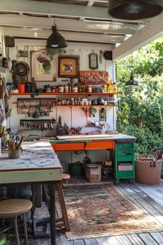 the inside of an art studio with lots of crafting supplies on shelves and desks