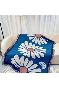 a blue and white blanket sitting on top of a couch