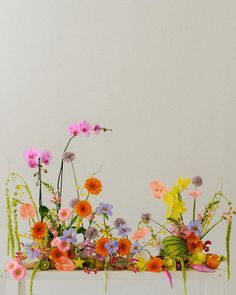 an arrangement of colorful flowers on a white table