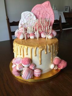 a birthday cake decorated with pink and white candy, marshmallows and icing