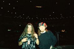 two young men standing next to each other in front of a crowd at a concert