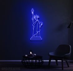 the statue of liberty neon sign is on display in a dark room with a black table and chair