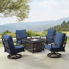 an outdoor fire pit surrounded by blue chairs