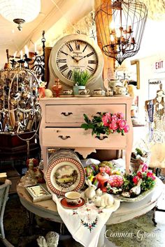 there is a table that has many items on it and a clock in the background