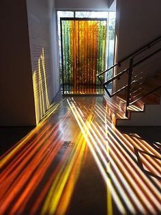 the light is shining through the blinds on the stairs in the house and onto the floor