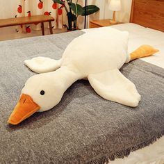 a stuffed duck laying on top of a bed