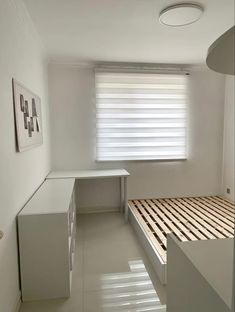 a bedroom with a bed, desk and window in the corner on the far wall