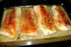 four fish fillets in a baking pan ready to be baked into the oven for dinner