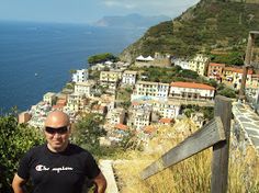 a man standing on top of a hill next to the ocean