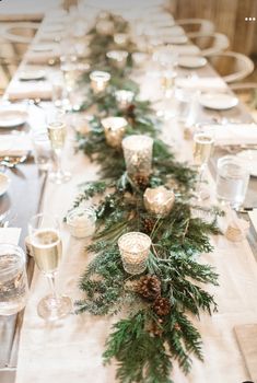 a long table is set with candles and greenery for a festive holiday dinner