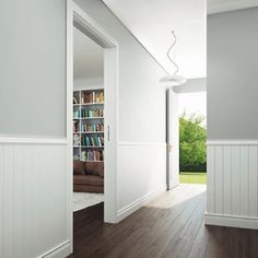 an open door leading to a living room with bookshelf and couch in it