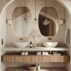 a bathroom with two round mirrors above the sinks and lights hanging from the ceiling over the sink