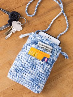 a cell phone and keys on a wooden floor next to a purse with a credit card in it