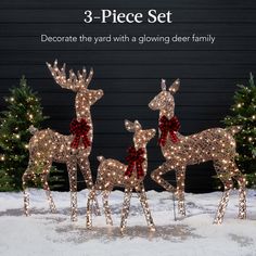 three reindeers with red bows are standing in the snow next to christmas trees and lights