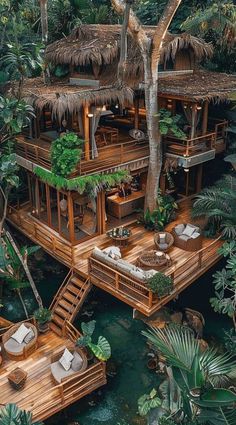 an aerial view of a tropical house in the middle of trees and water with stairs leading up to it