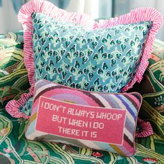 a pillow with a message on it sitting on a chair next to a wall and window