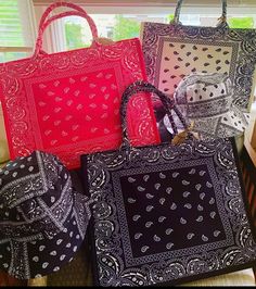 four bags are stacked on top of each other in different colors and patterns, one is red, the other is black