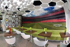 the interior of a sports bar with tables and chairs in front of a large soccer field