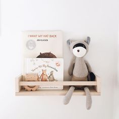 a stuffed animal sitting on top of a wooden shelf